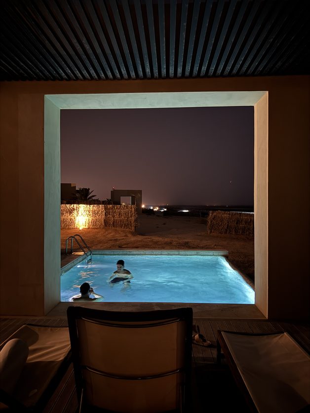 A lit pool at night, seen through a doorway at a team retreat