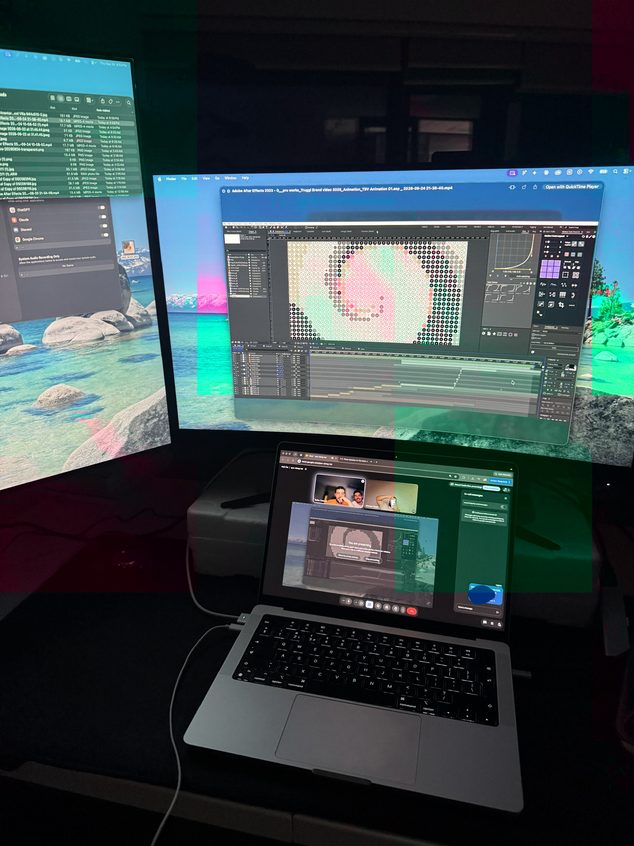 A desk with a laptop and two monitors open on animation work