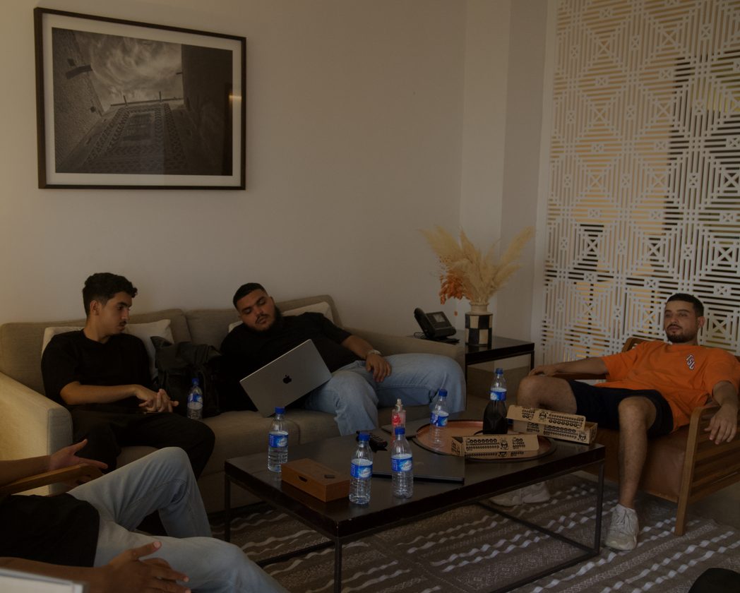 Three teammates relaxing on sofas in a hotel lounge